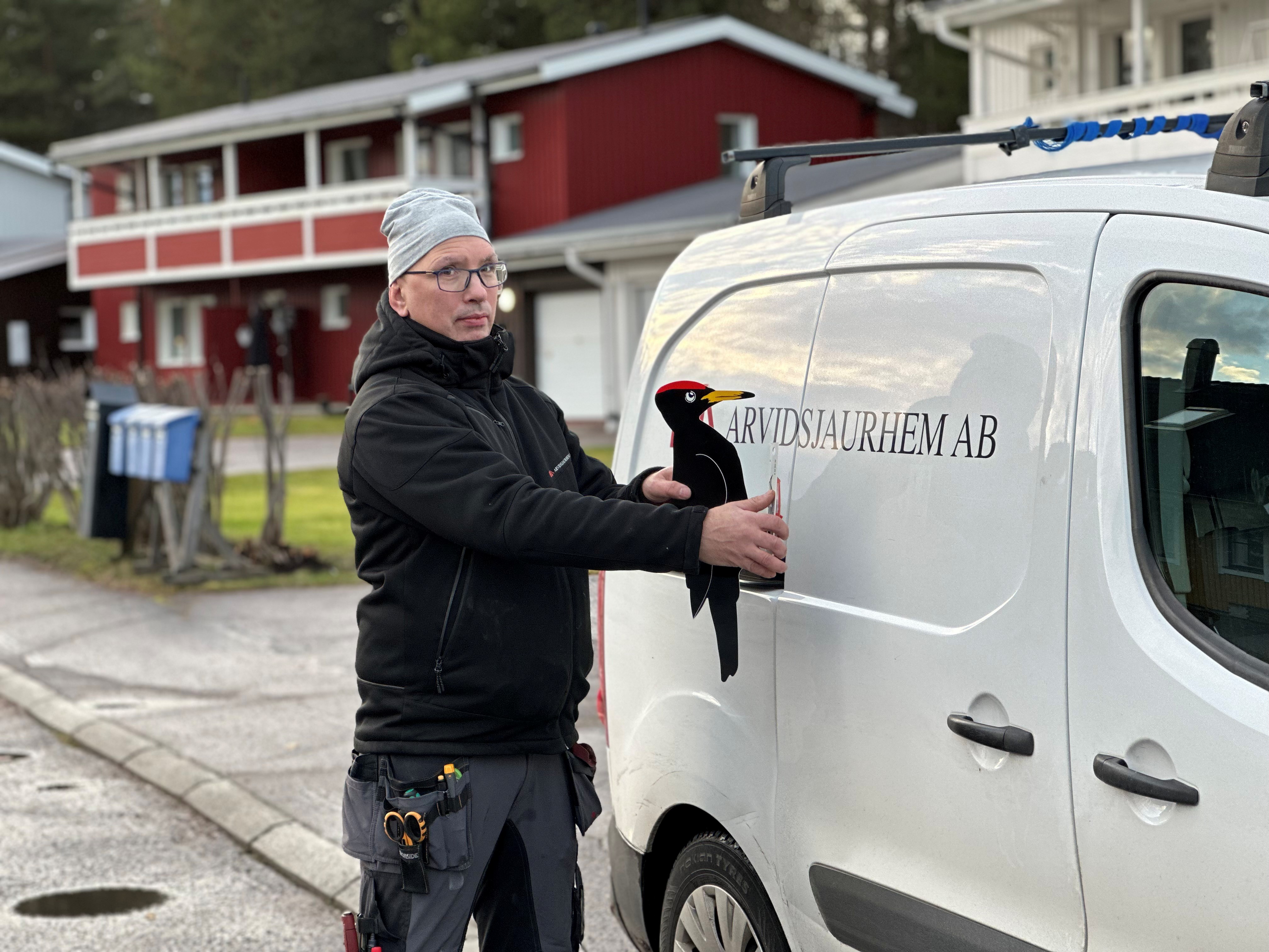 Per-Erik håller upp en attrapp på en Spillkråka i plåt. 